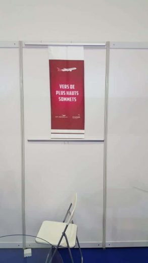 Fabric banner with metal bar with hooks on exhibition panels